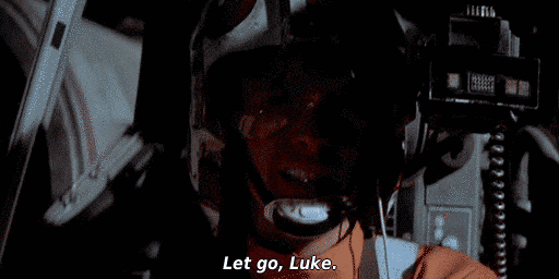 Screenshot of the scene from Star Wars Ep. IV where Luke is in the cockpit of his X-Wing and he hears the voice of Obiwan say, “Let go, Luke.”