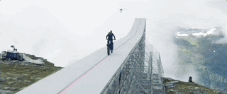 Animated GIF from the “Mission Impossible” promo showing Tom Cruise jump a motorcycle off a ramp and free fall down to earth.